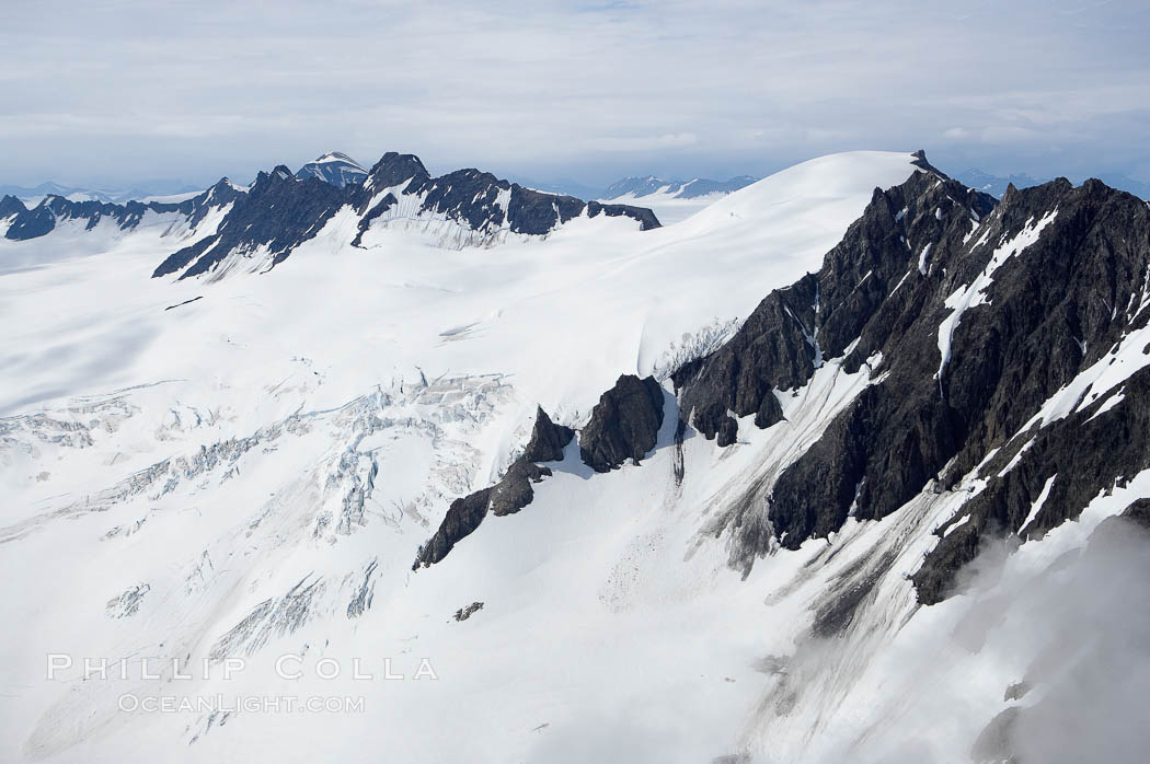 The Kenai Mountains rise above thick ice sheets and the Harding Icefield which is one of the largest icefields in Alaska and gives rise to over 30 glaciers. Kenai Fjords National Park, USA, natural history stock photograph, photo id 19017