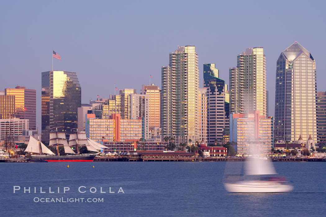 San Diego city skyline at dusk, viewed from Harbor Island, a sailboat cruises by in the foreground, the Star of India at left. California, USA, natural history stock photograph, photo id 14526