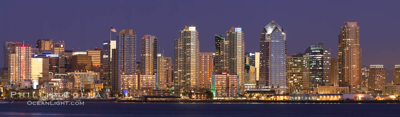 San Diego city skyline at sunset, showing the buildings of downtown San Diego rising above San Diego Harbor, viewed from Harbor Island. A panoramic photograph, composite of thirteen separate images