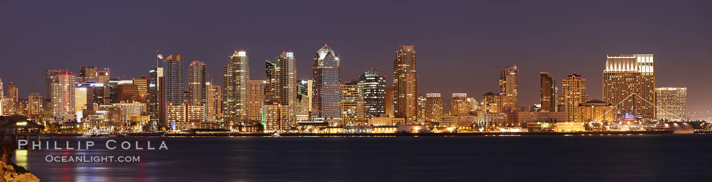 San Diego city skyline at sunset, showing the buildings of downtown San Diego rising above San Diego Harbor, viewed from Harbor Island. A panoramic photograph, composite of four separate images