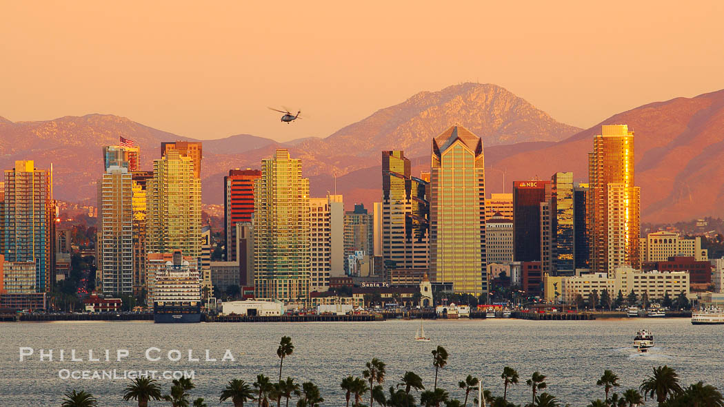 San Diego city skyline, showing the buildings of downtown San Diego rising above San Diego Harbor, viewed from Point Loma at sunset, with mountains of the Cleveland National Forest rising in the distance. Lyons Peak is in center and the flanks of Mount San Miguel to the right., natural history stock photograph, photo id 22260