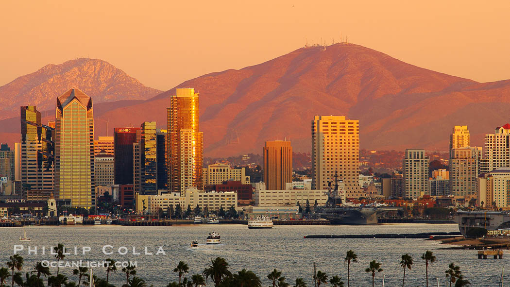 San Diego city skyline, showing the buildings of downtown San Diego rising above San Diego Harbor, viewed from Point Loma at sunset, with mountains of the Cleveland National Forest rising in the distance. Mount San Miguel is on the right and Lyons Peak to the left., natural history stock photograph, photo id 22263