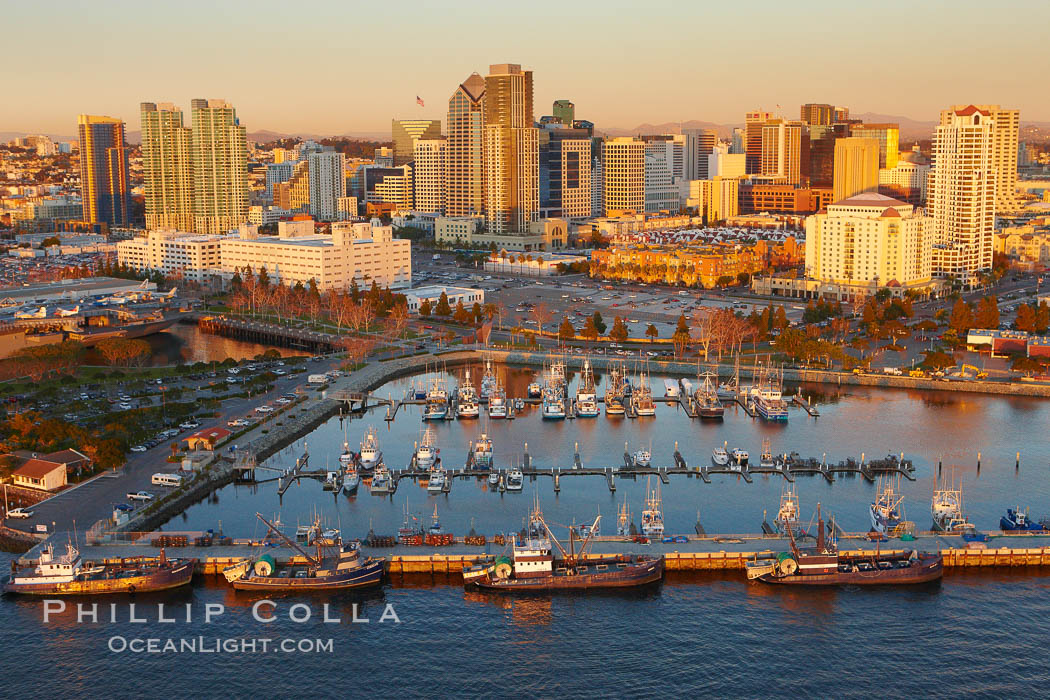 Aerial photo of San Diego Marina District, sunset, with fishing vessels docked alongside pier, Seaport Village (right) and downtown highrise office buildings rising over San Diego Bay. California, USA, natural history stock photograph, photo id 22420