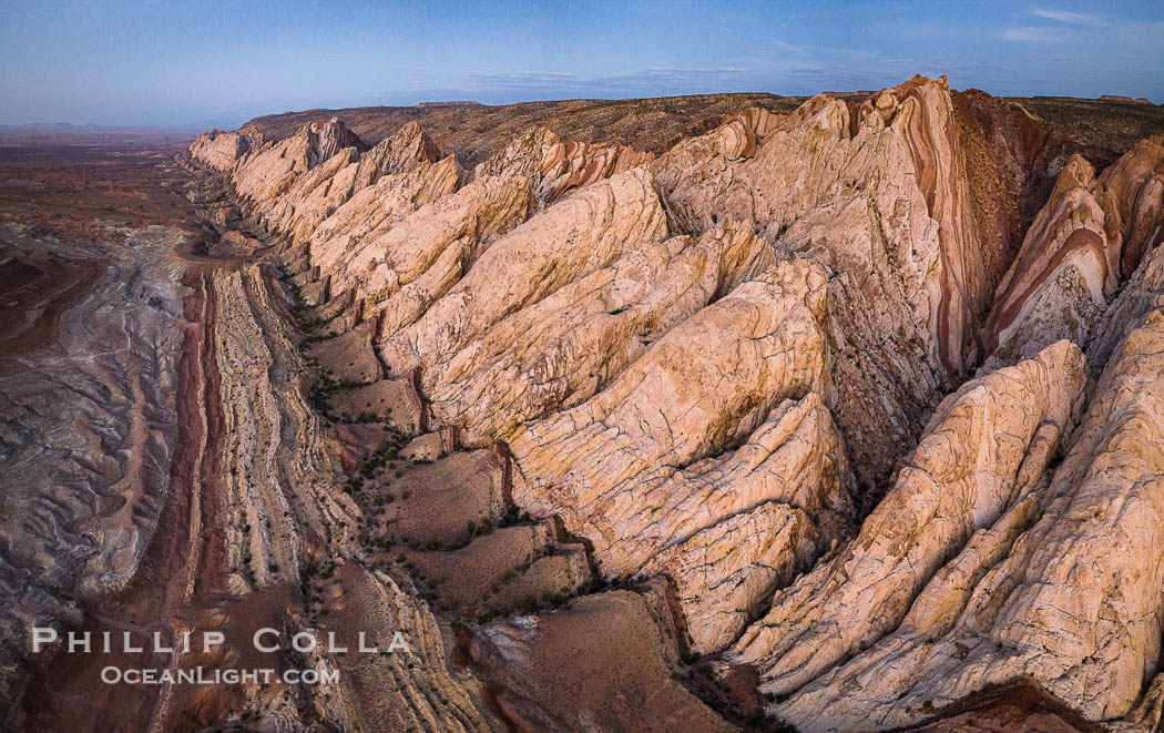 Aerial photo of the San Rafael Reef at dawn.  A fold in the Earth's crust leads to this inclined section of the San Rafael Reef, at the eastern edge of the San Rafael Swell.  Clearly seen are the characteristic triangular flatiron erosion patterns that typical this formation. The colors seen here arise primarily from Navajo and Wingate sandstone. Utah, USA, natural history stock photograph, photo id 39787