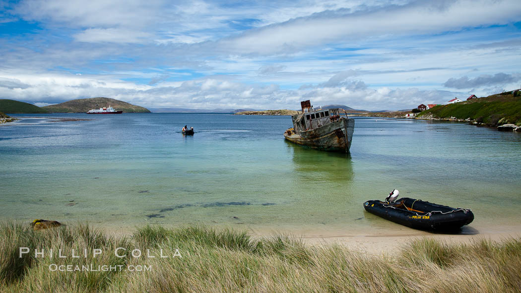 Sand beach at New Island Settlement, with zodiac ashore and shipwrreck