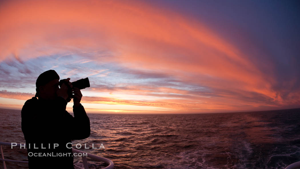 Photographer takes picture of a spectacular sunset arch, spanning the heavens from horizon to horizon, over the open sea between the Falkland Islands and South Georgia Island