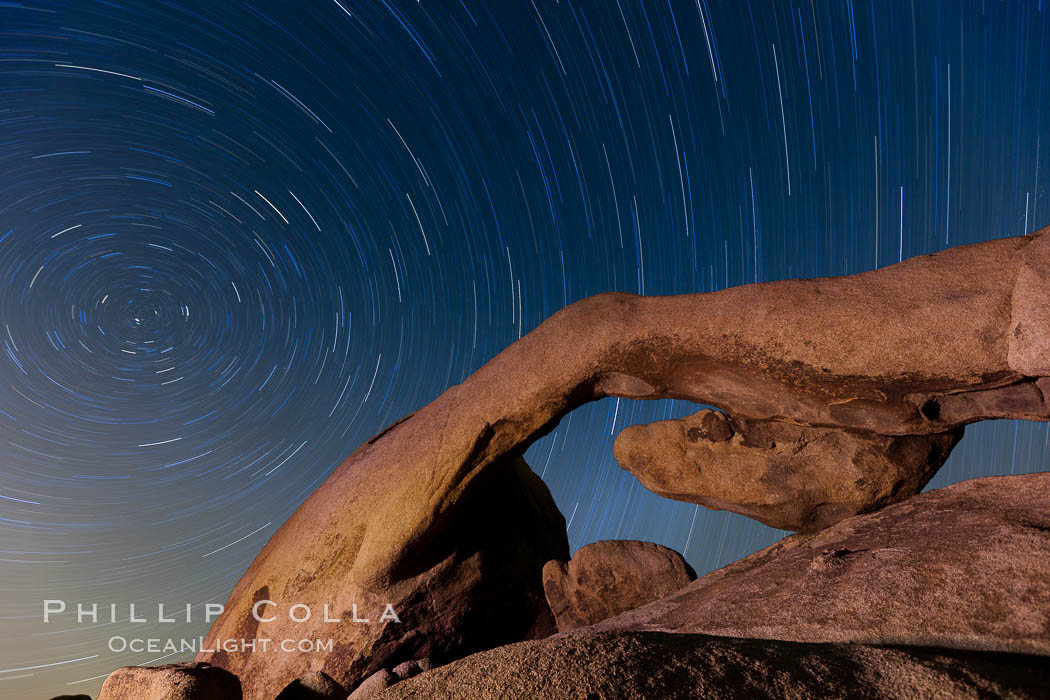 Star trails and Arch Rock.  Polaris, the North Star, is at the center of the circular arc star trails as they pass above this natural stone archway in Joshua Tree National Park. California, USA, natural history stock photograph, photo id 26794