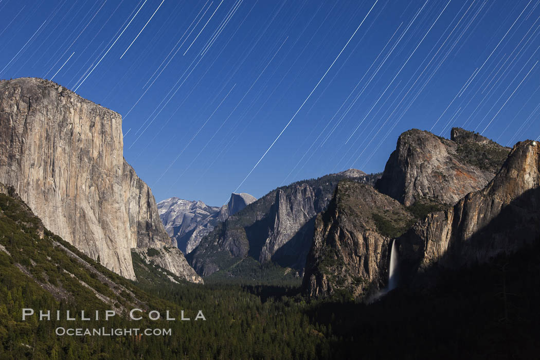 Star trails over Yosemite Valley, viewed from Tunnel View, the floor of Yosemite Valley illuminated by a full moon.  El Capitan on left, Bridalveil Falls on right, Half Dome in distant center. Yosemite National Park, California, USA, natural history stock photograph, photo id 27735