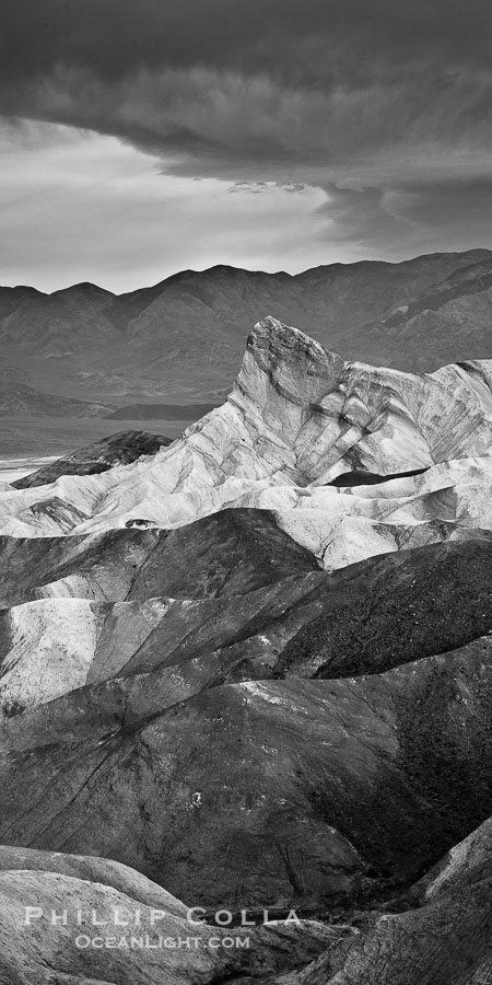 Sunrise at Zabriskie Point, Manly Beacon is lit by the morning sun while dark clouds lie on the horizon., natural history stock photograph, photo id 26386