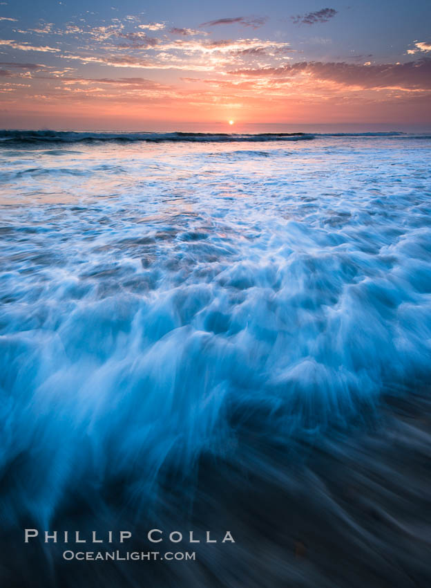 Sunset and incoming surf, gorgeous colors in the sky and on the ocean at dusk, the incoming waves are blurred in this long exposure, Carlsbad, California