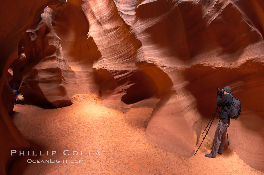 A photographer works amidst the striated walls and dramatic light within Antelope Canyon, a deep narrow slot canyon formed by water and wind erosion. Navajo Tribal Lands, Page, Arizona, USA, natural history stock photograph, photo id 18011