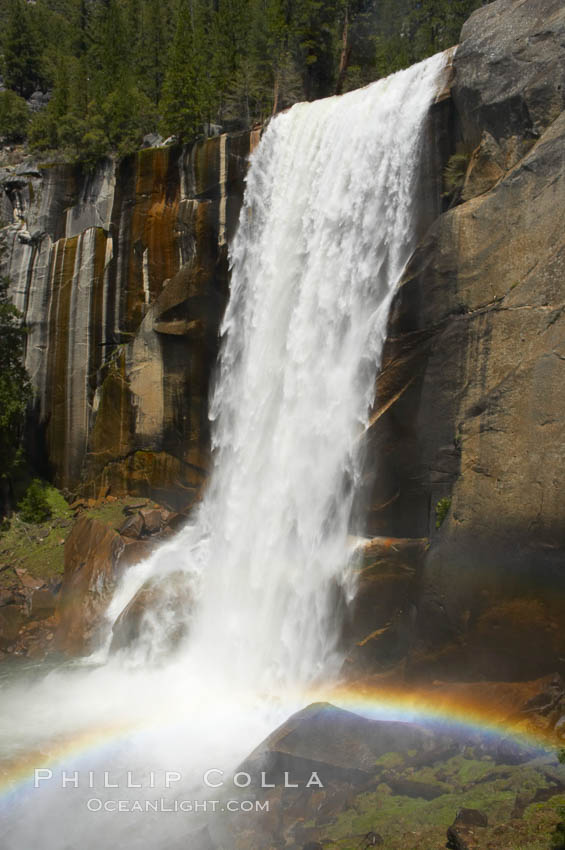 Vernal Falls at peak flow in late spring, with a rainbow appearing in the spray of the falls, viewed from the Mist Trail, Yosemite National Park, California