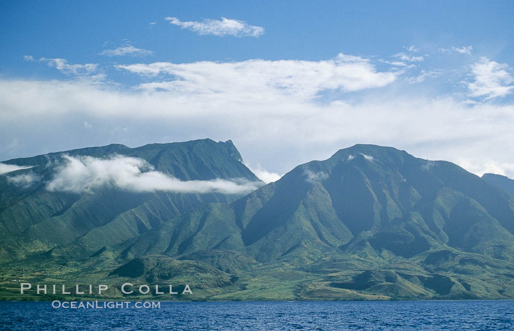 West Maui mountains rise above the coast of Maui, with clouds flanking the ancient eroded remnants of a volcano. Hawaii, USA, natural history stock photograph, photo id 05862