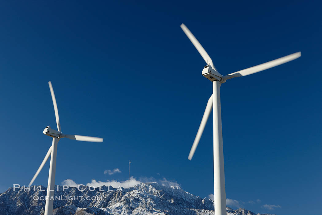 Wind turbines, rise above the flat floor of the San Gorgonio Pass near Palm Springs, with snow covered Mount San Jacinto in the background, provide electricity to Palm Springs and the Coachella Valley. California, USA, natural history stock photograph, photo id 22206