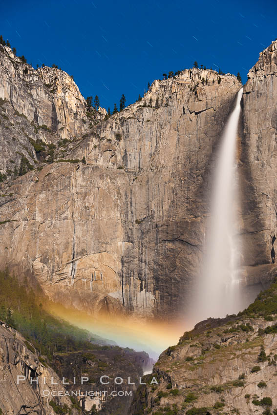 Upper Yosemite Falls and lunar rainbow, moonbow. A lunar rainbow (moonbow) can be seen to the left of Yosemite Falls, where the moon illuminates the spray of the falls, Yosemite National Park, California