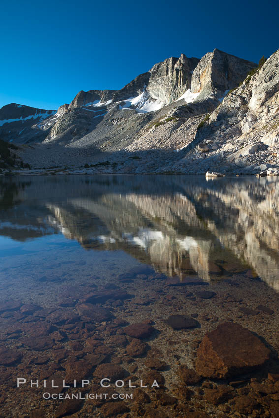 Cathedral Range peaks reflected in the still waters of Townsley Lake at sunrise, Yosemite National Park, California