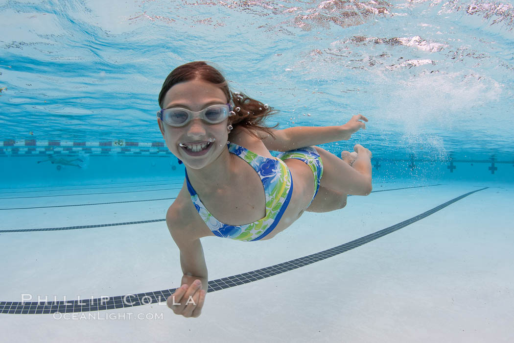 A young girl has fun swimming in a pool