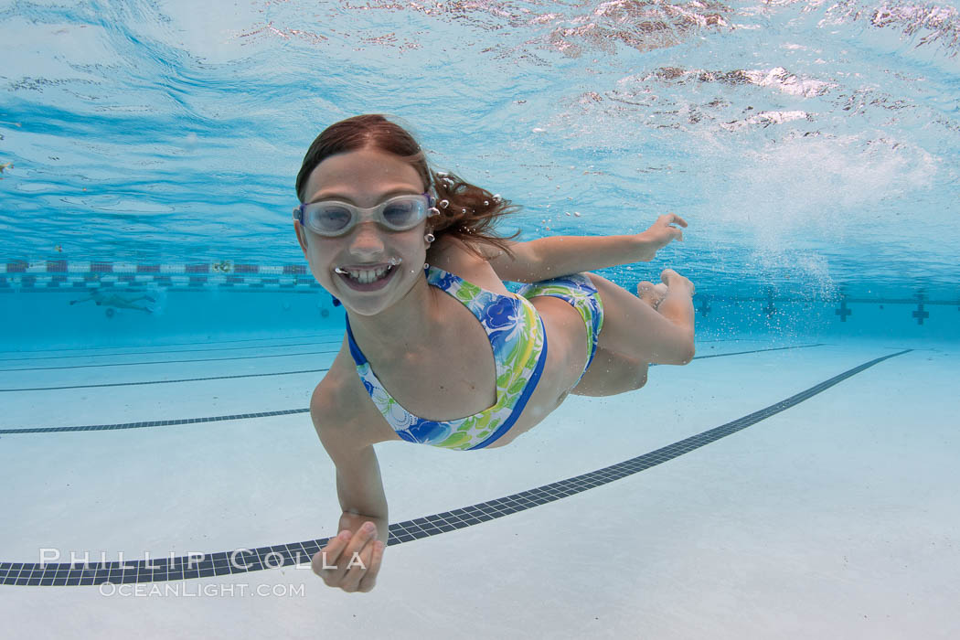 A young girl has fun swimming in a pool