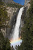 Bridalveil Falls with a rainbow forming in its spray, dropping 620 into Yosemite Valley, displaying peak water flow in spring months from deep snowpack and warm weather melt.  Yosemite Valley. Yosemite National Park, California, USA
