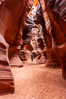 A hiker admiring the striated walls and dramatic light within Antelope Canyon, a deep narrow slot canyon formed by water and wind erosion. Navajo Tribal Lands, Page, Arizona, USA. Image #17993