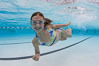 A young girl has fun swimming in a pool. Image #25291