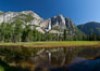 Yosemite Falls reflected in flooded meadow.  The Merced  River floods its banks in spring, forming beautiful reflections of Yosemite Falls. Yosemite National Park, California, USA