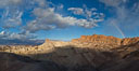 Sunrise at Zabriskie Point, Manly Beacon is lit by the morning sun while clouds from a clearing storm pass by. Death Valley National Park, California, USA