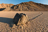 Sailing stone on the Racetrack Playa. The sliding rocks, or sailing stones, move across the mud flats of the Racetrack Playa, leaving trails behind in the mud. The explanation for their movement is not known with certainty, but many believe wind pushes the rocks over wet and perhaps icy mud in winter. Death Valley National Park, California, USA. Image #27689