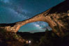Owachomo Bridge and Milky Way.  Owachomo Bridge, a natural stone bridge standing 106' high and spanning 130' wide,stretches across a canyon with the Milky Way crossing the night sky. Natural Bridges National Monument, Utah, USA. Image #28541
