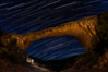 Owachomo Bridge and Star Trails, at night.  Owachomo Bridge, a natural stone bridge standing 106' high and spanning 130' wide,stretches across a canyon with the Milky Way crossing the night sky. Natural Bridges National Monument, Utah, USA. Image #28550