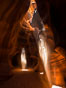 Light Beam in Upper Antelope Slot Canyon.  Thin shafts of light briefly penetrate the convoluted narrows of Upper Antelope Slot Canyon, sending piercing beams through the sandstone maze to the sand floor below. Navajo Tribal Lands, Page, Arizona, USA. Image #28561