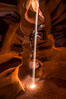 Light Beam in Upper Antelope Slot Canyon.  Thin shafts of light briefly penetrate the convoluted narrows of Upper Antelope Slot Canyon, sending piercing beams through the sandstone maze to the sand floor below. Navajo Tribal Lands, Page, Arizona, USA. Image #28570