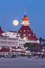 Full Moon Rising over Hotel del Coronado, known affectionately as the Hotel Del. It was once the largest hotel in the world, and is one of the few remaining wooden Victorian beach resorts. It sits on the beach on Coronado Island, seen here with downtown San Diego in the distance. It is widely considered to be one of Americas most beautiful and classic hotels. Built in 1888, it was designated a National Historic Landmark in 1977. California, USA. Image #29420