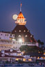 Full Moon Rising over Hotel del Coronado, known affectionately as the Hotel Del. It was once the largest hotel in the world, and is one of the few remaining wooden Victorian beach resorts. It sits on the beach on Coronado Island, seen here with downtown San Diego in the distance. It is widely considered to be one of Americas most beautiful and classic hotels. Built in 1888, it was designated a National Historic Landmark in 1977. California, USA. Image #29421