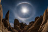 Full moon with 22-degree lunar halo, Joshua Tree National Park.  The lunar halo (not to be cofused with lunar corona) forms when moonlight refracts through high altitude ice crystals. As no light is refracted at angles smaller than 22-degrees the sky is darker inside the halo. California, USA. Image #30711