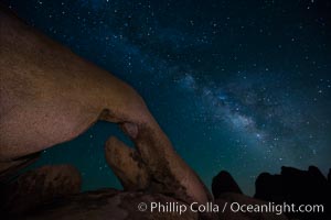 The Milky Way galaxy arcs over Arch Rock on a clear evening in Joshua Tree National Park