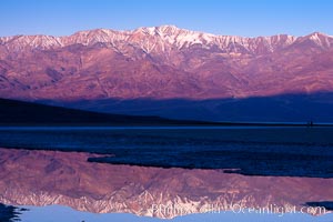 Sunrise lights Telescope Peak as it rises over the salt flats of Badwater, Death Valley.  At 11,049 feet, Telescope Peak is the highest peak in the Panamint Range as well as the highest point in Death Valley National Park.  At 282 feet below sea level, Badwater is the lowest point in North America