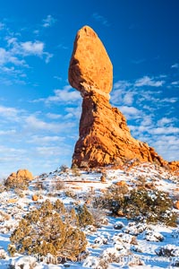 Balanced Rock, a narrow sandstone tower, appears poised to topple.  Sunset, winter, Arches National Park, Utah