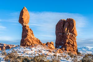 Balanced Rock, a narrow sandstone tower, appears poised to topple.  Sunset, winter, Arches National Park, Utah