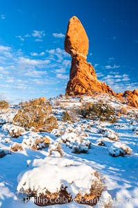 Balanced Rock, a narrow sandstone tower, appears poised to topple.  Sunset, winter, Arches National Park, Utah