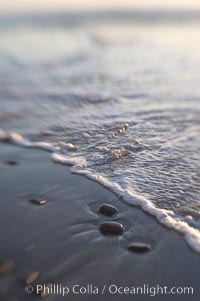 Beach stones, sea water, sand, reflections of sunset, Ponto, Carlsbad, California