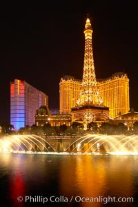 The Bellagio Hotel fountains light up the reflection pool as the half-scale replica of the Eiffel Tower at the Paris Hotel in Las Vegas rises above them, at night