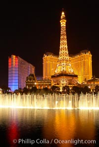 The Bellagio Hotel fountains light up the reflection pool as the half-scale replica of the Eiffel Tower at the Paris Hotel in Las Vegas rises above them, at night