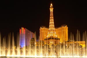 The Bellagio Hotel fountains light up the reflection pool as the half-scale replica of the Eiffel Tower at the Paris Hotel in Las Vegas rises above them, at night