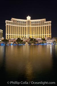 The Bellagio Hotel reflected in the fountain pool at night.  The Bellagio Hotel fountains are one of the most popular attractions in Las Vegas, showing every half hour or so throughout the day, choreographed to famous Hollywood music