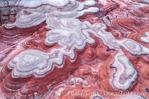 Fantastic colorful sedimentary patterns of Bentonite layers, seen as striations exposed in the Utah Badlands. The Bentonite Hills are composed of the Brushy Basin shale member of the Morrison Formation formed during Jurassic times when mud, silt, fine sand, and volcanic ash were deposited in swamps and lakes into layers, now revealed through erosion. Aerial photograph.