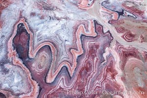 Fantastic colorful sedimentary patterns of Bentonite layers, seen as striations exposed in the Utah Badlands. The Bentonite Hills are composed of the Brushy Basin shale member of the Morrison Formation formed during Jurassic times when mud, silt, fine sand, and volcanic ash were deposited in swamps and lakes into layers, now revealed through erosion. Aerial photograph