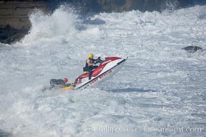 Lifeguards on a jet ski assist a surfer caught inside.  La Jolla Cove.  Giant surf and big waves nail Southern California, December 21, 2005