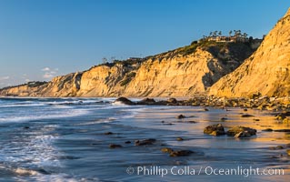 Black's Beach sea cliffs, sunset, looking north from Scripps Pier with Torrey Pines State Reserve in the distance, La Jolla, California