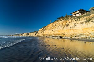 Black's Beach sea cliffs, sunset, looking north from Scripps Pier with Torrey Pines State Reserve in the distance, La Jolla, California